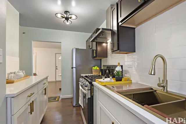 a kitchen with stainless steel appliances a sink a stove and cabinets