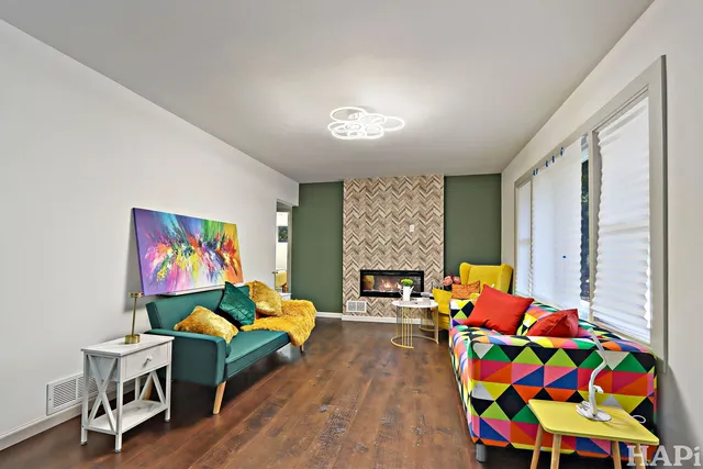 a living room with furniture fireplace and a large window