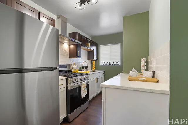a kitchen with a refrigerator sink stove and cabinets