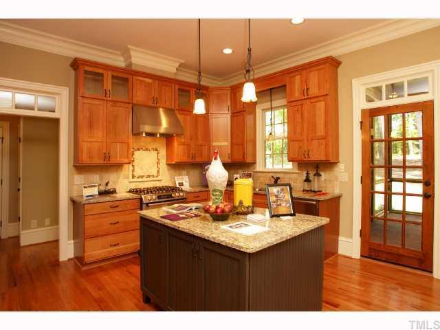 4843 Inwood Road Raleigh, NC 27603 - Photo 7 of 12 a kitchen with a sink stove and wooden cabinets