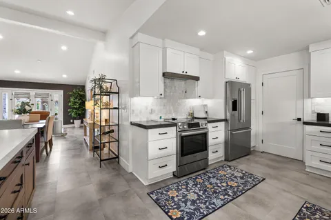 a kitchen with stainless steel appliances kitchen island granite countertop a refrigerator and a stove top oven