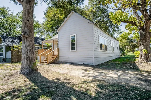 a view of a house with a tree in the yard