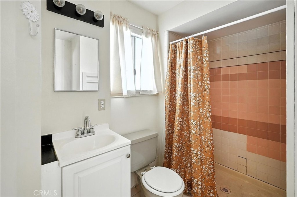 9953 La Tuna Canyon Road Sun Valley, CA 91352 - Photo 22 of 32 a bathroom with a sink a toilet and shower curtain
