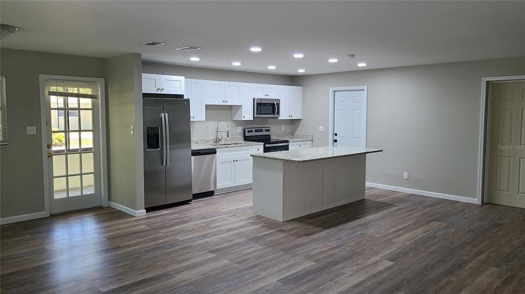 4611 West Villa Rosa Street Tampa, FL 33611 - Photo 4 of 22 a kitchen with stainless steel appliances a refrigerator and wooden floor