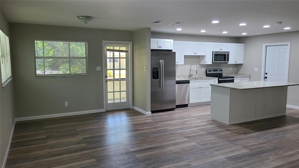 4611 West Villa Rosa Street Tampa, FL 33611 - Photo 5 of 22 a kitchen with stainless steel appliances granite countertop a refrigerator stove top oven and cabinets with wooden floor