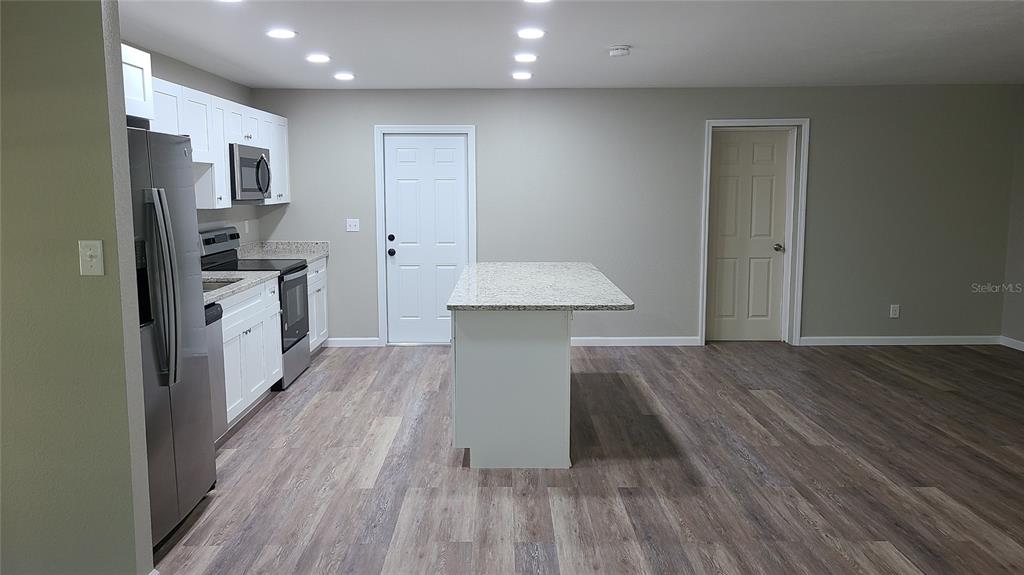 4611 West Villa Rosa Street Tampa, FL 33611 - Photo 6 of 22 a kitchen with kitchen island wooden floors and stainless steel appliances