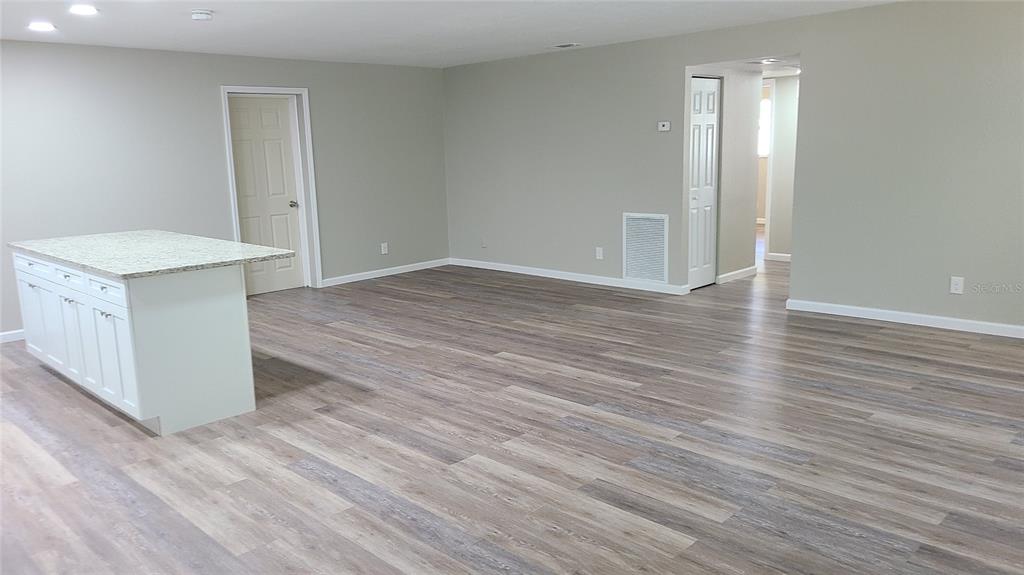 4611 West Villa Rosa Street Tampa, FL 33611 - Photo 7 of 22 an empty room with wooden floor and mirror