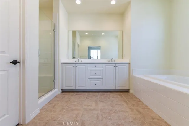 a bathroom with a granite countertop sink a large mirror a bathtub and window