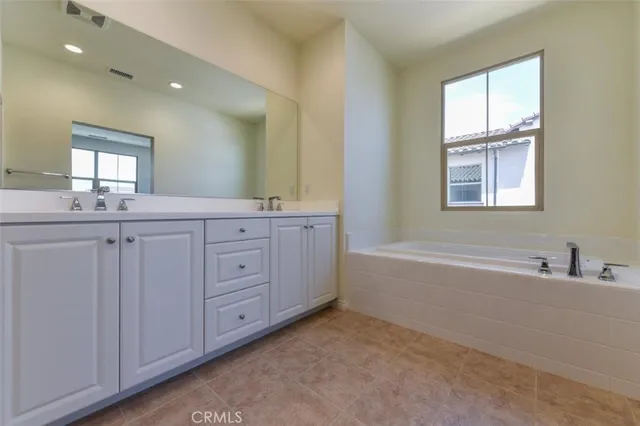 a bathroom with a granite countertop sink a mirror and a bathtub