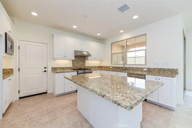 a large kitchen with stainless steel appliances lots of counter top space