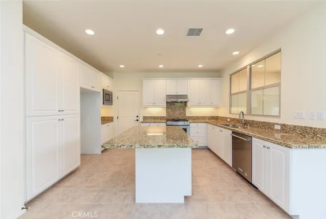 a view of an empty room with a kitchen