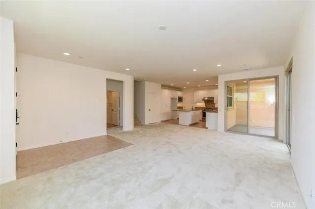 a large kitchen with kitchen island a sink a stove a refrigerator and white cabinets