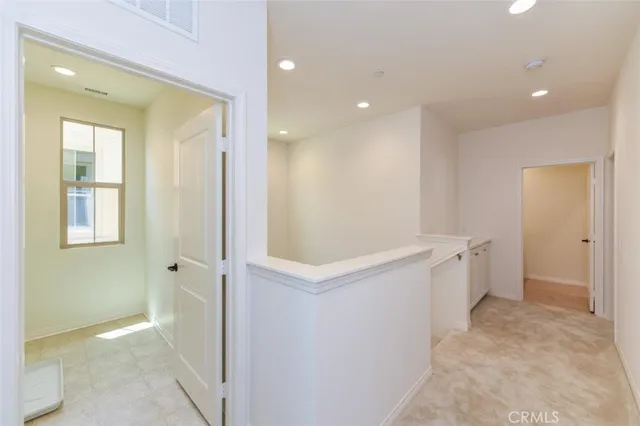 a view of an empty room with window and stairs
