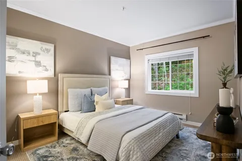 a bedroom with a bed and a mirror on the dresser