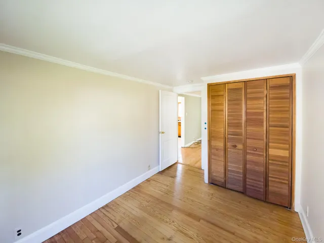 an empty room with wooden floor and cabinet