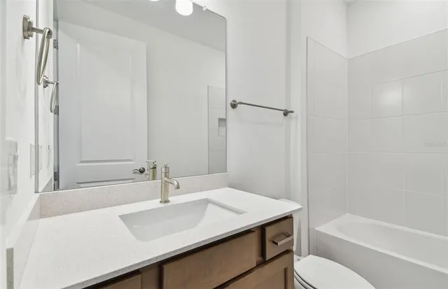 a bathroom with a sink toilet vanity and shower