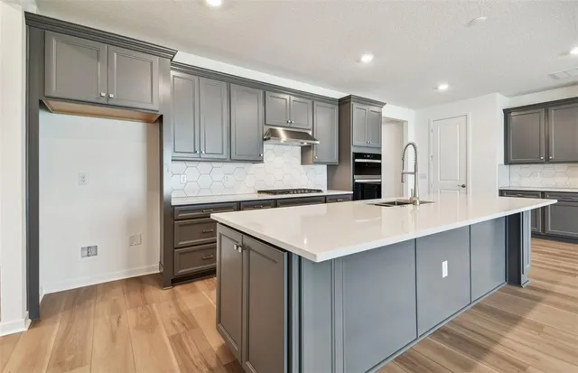 a kitchen with kitchen island a sink stainless steel appliances and cabinets