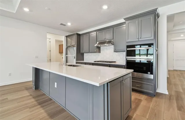 a kitchen with kitchen island white cabinets and refrigerator