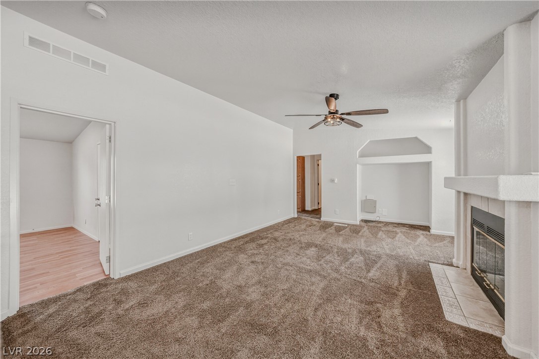1890 West Dyer Road Pahrump, NV 89048 - Photo 20 of 40 This inviting living space features cozy carpet flooring and a charming fireplace.