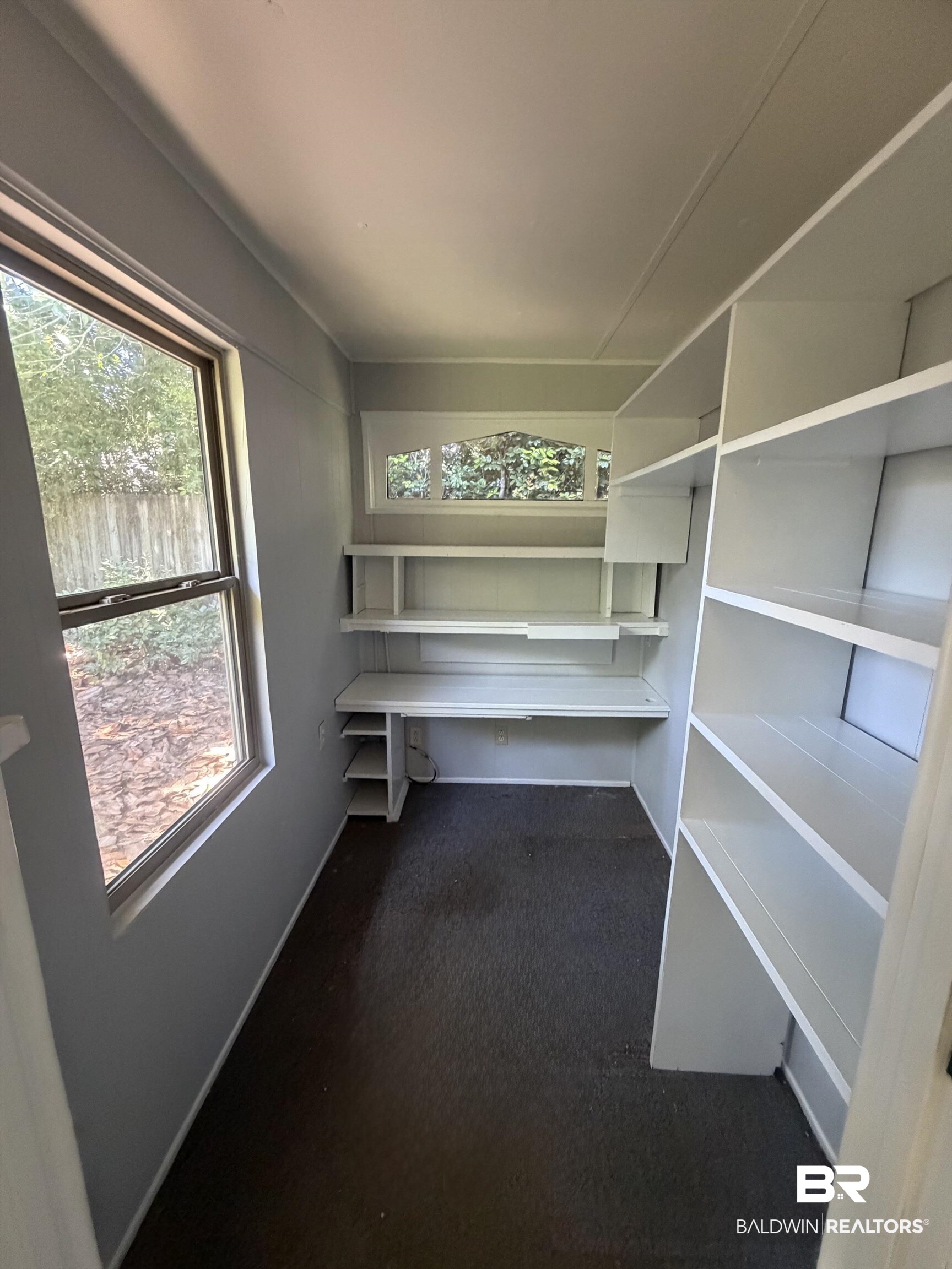 1354 Caney Loop Lillian, AL 36549 - Photo 17 of 45 Dedicated workspace featuring a built-in desk, integrated shelving, and two distinct windows including an arched transom