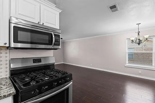 a kitchen with granite countertop stainless steel appliances and white cabinets