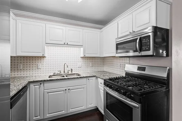 a kitchen with cabinets stainless steel appliances a sink dishwasher and microwave