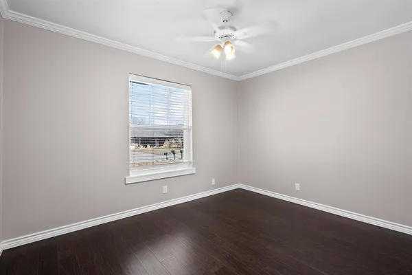 an empty room with wooden floor and window