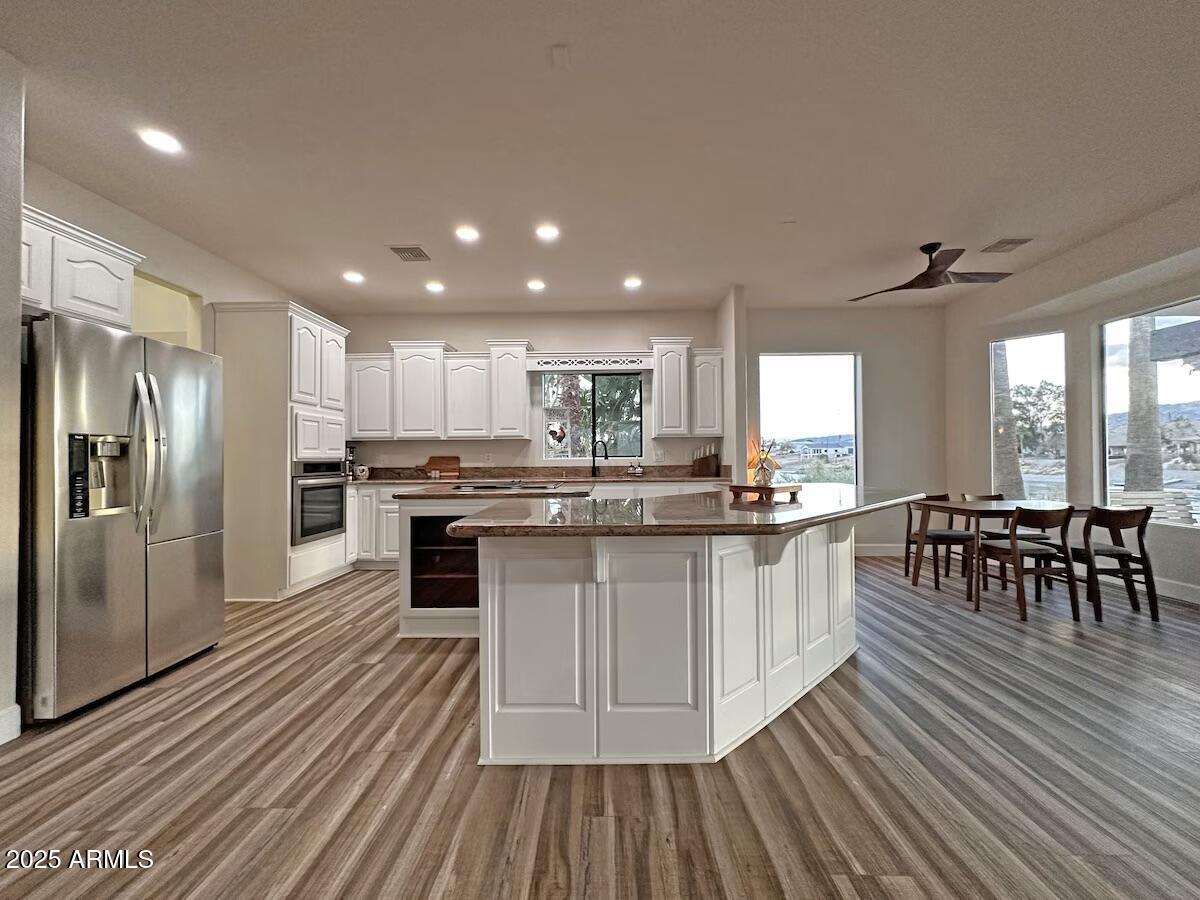 9755 Dike Road Mohave Valley, AZ 86440 - Photo 10 of 50 a kitchen with stainless steel appliances granite countertop a stove refrigerator and a dining table with wooden floor