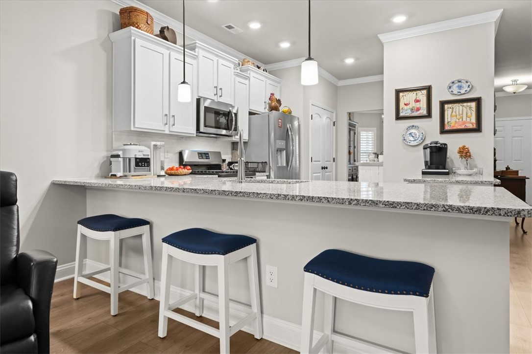 119 Shipyard Circle Anderson, SC 29621 - Photo 20 of 50 Gleaming granite countertops define this modern kitchen, offering both workspace and a casual dining area.
