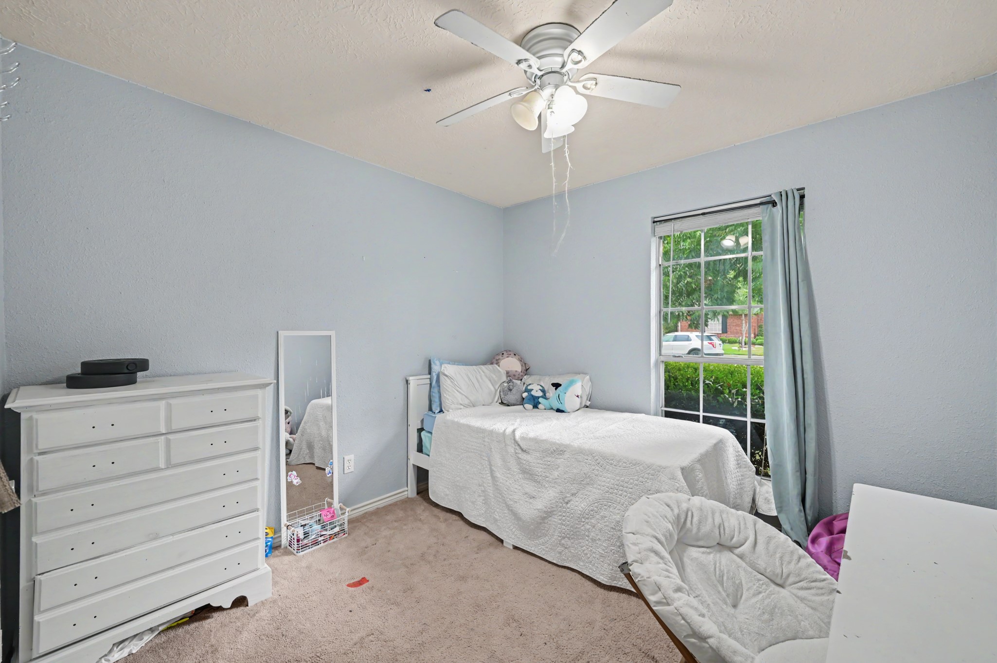 5226 Clarkston Lane Spring, TX 77379 - Photo 22 of 25 Secondary bedroom 2 with soft grey walls and ceiling fan facing the front of the home.