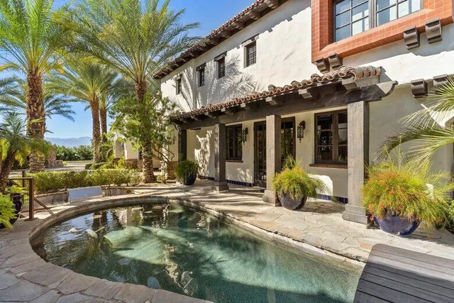 a living room with patio furniture and a potted plant