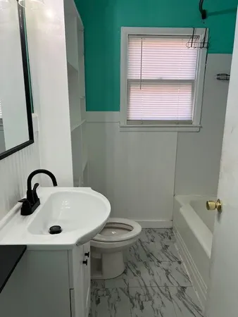 a bath tub sitting next to a white sink and vanity