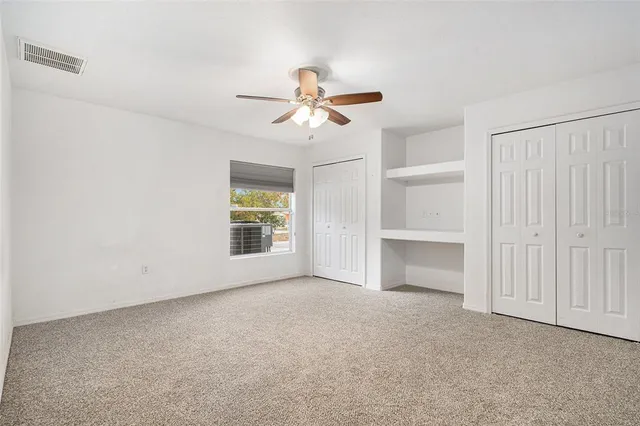 a view of an empty room with a ceiling fan