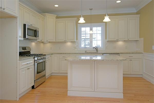a kitchen with granite countertop white cabinets and white stainless steel appliances