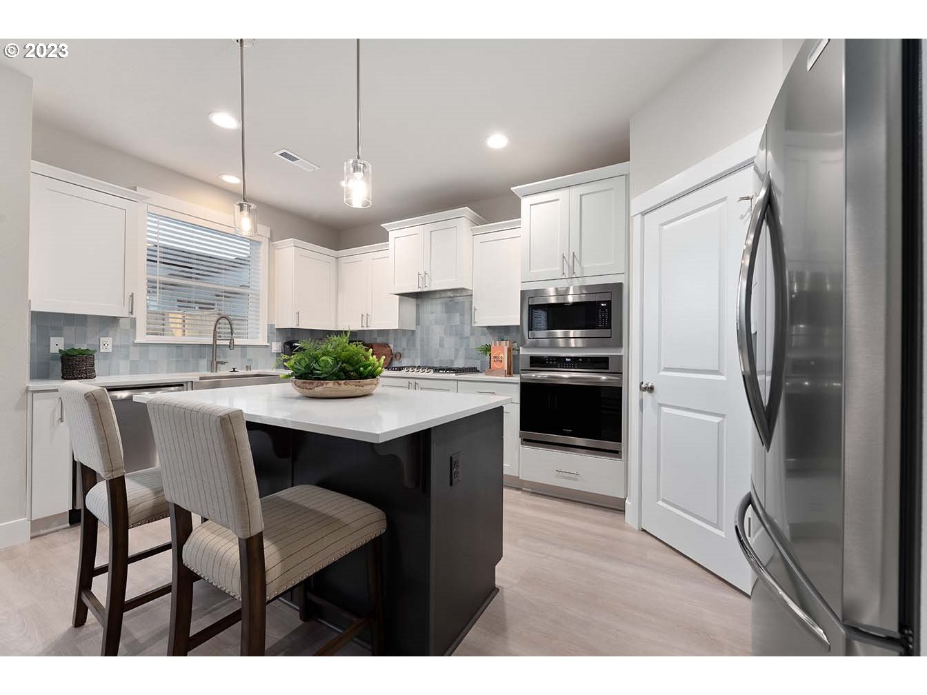 8903 North 5th Street, Unit 63 Ridgefield, WA 98642 - Photo 11 of 32 a kitchen with stainless steel appliances granite countertop a refrigerator a sink dishwasher a stove and white cabinets with wooden floor