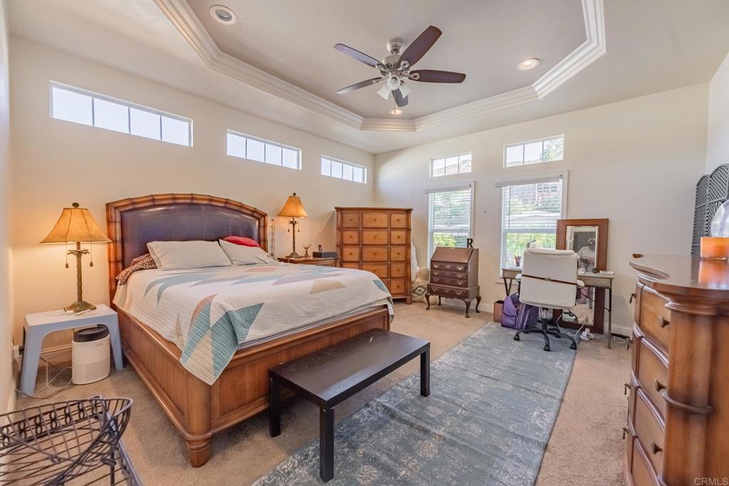 4650 Dulin Road, Unit 126 Fallbrook, CA 92003 - Photo 11 of 41 a spacious bedroom with a bed a table and a chandelier