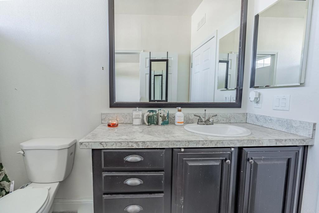4650 Dulin Road, Unit 126 Fallbrook, CA 92003 - Photo 17 of 41 a bathroom with a granite countertop toilet sink and mirror