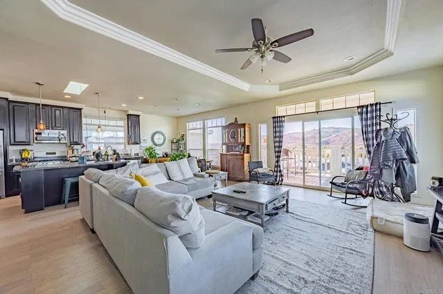 a living room with furniture kitchen area and large windows