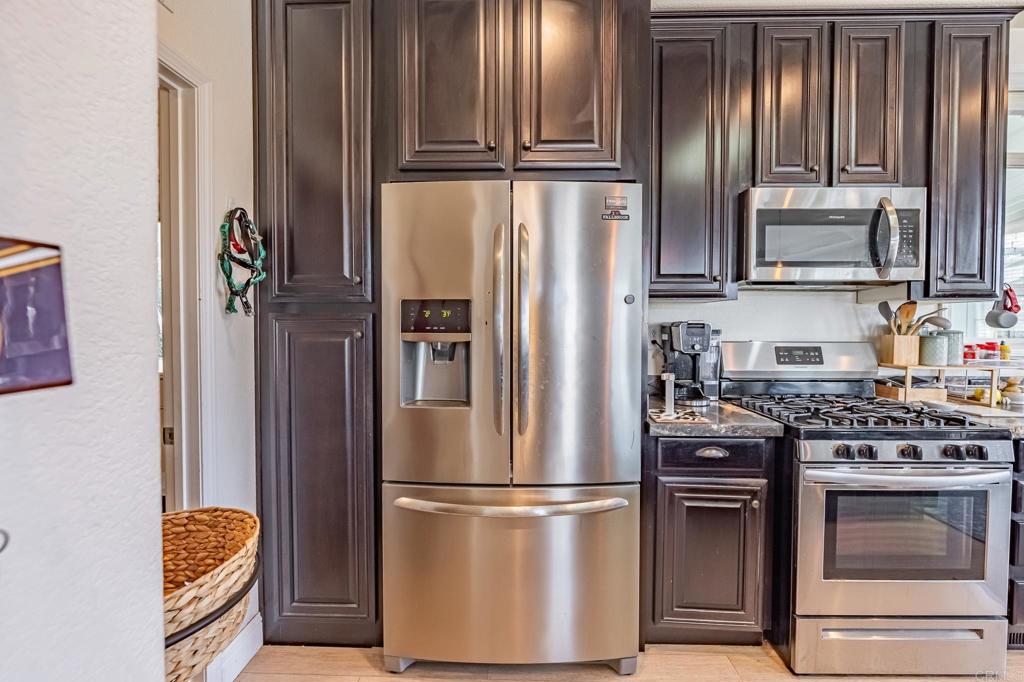 4650 Dulin Road, Unit 126 Fallbrook, CA 92003 - Photo 8 of 41 a kitchen with stainless steel appliances granite countertop a refrigerator stove and microwave