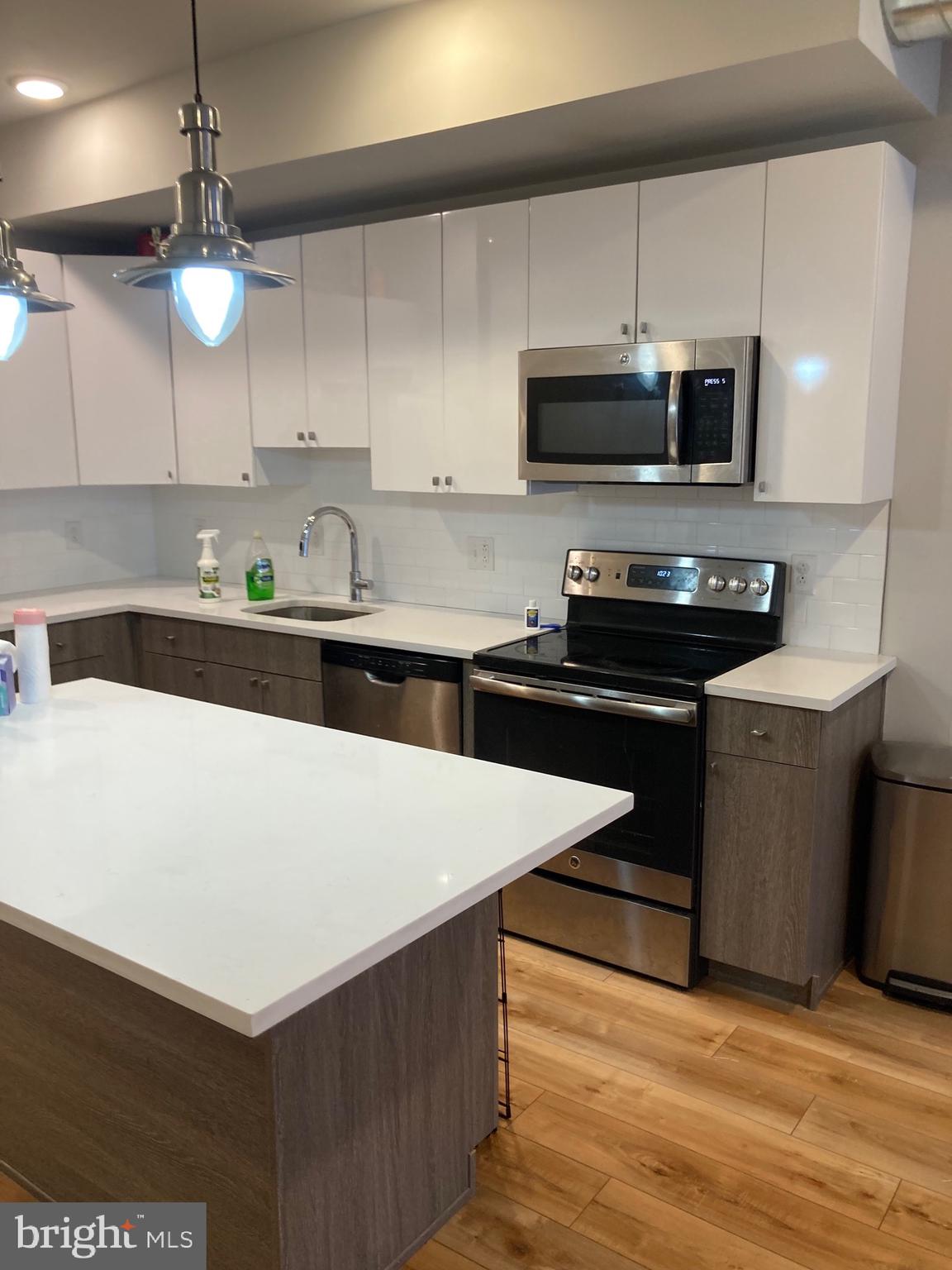 2553 North Front Street, Unit 3 Philadelphia, PA 19133 - Photo 4 of 16 a kitchen with stainless steel appliances a stove a sink a microwave and cabinets