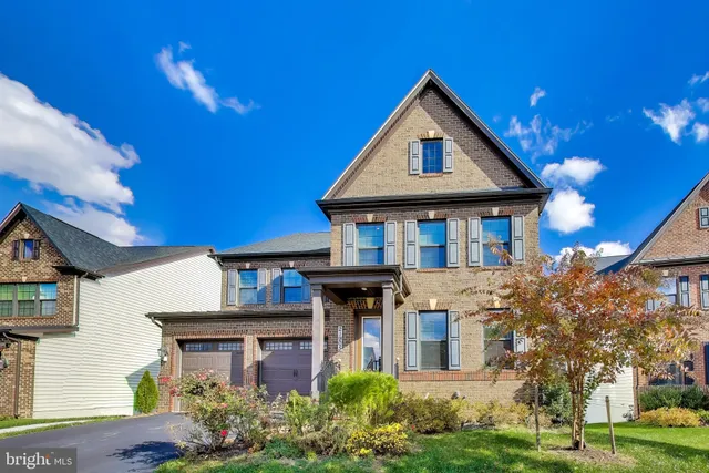 a front view of a residential houses with yard and green space