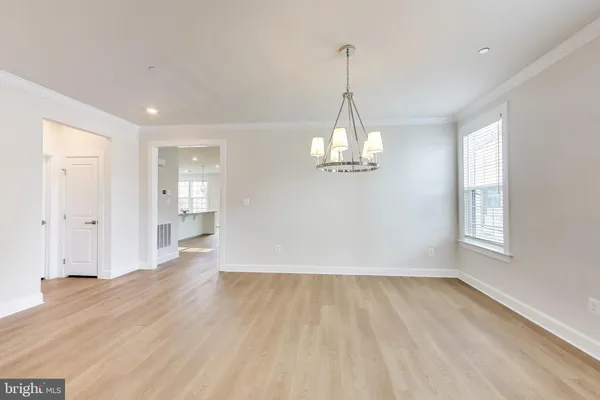 a view of empty room with wooden floor and window