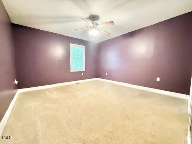 an empty room with windows and ceiling fan view