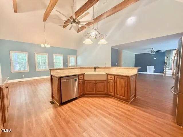 a view of a kitchen with kitchen island wooden floors stainless steel appliances