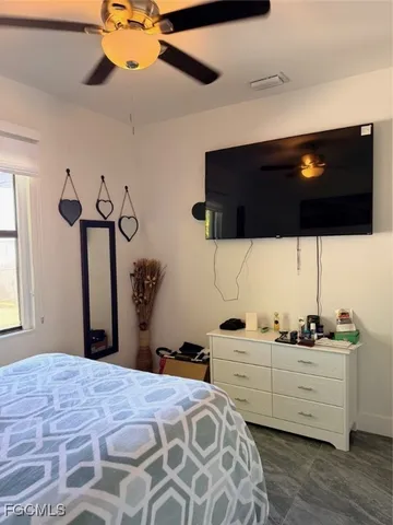 a bedroom with a bed and ceiling fan