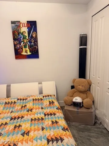 a bedroom with a bed and painting on the wall