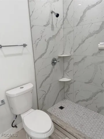a white toilet sitting next to a shower