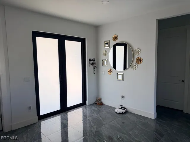 a view of a hallway with wooden floor and mirror
