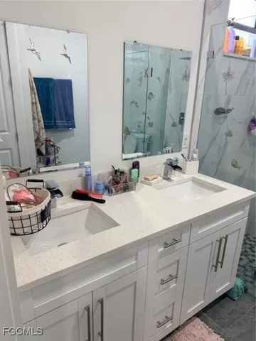 a bathroom with a double vanity sink mirror and bathtub