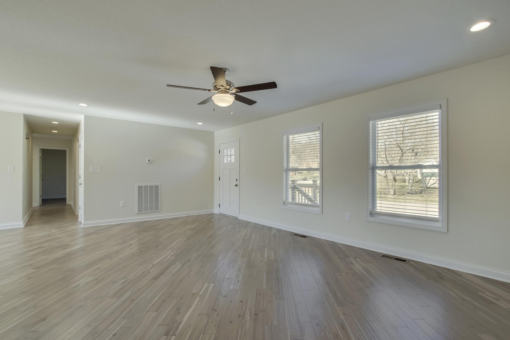 223 Butler Road Oak Ridge, TN 37830 - Photo 3 of 27 an empty room with wooden floor fan and windows